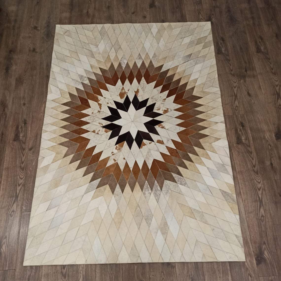 Handmade Cow Skin Rug featuring a star pattern, showcasing natural leather texture and elegant design, perfect for home decor.