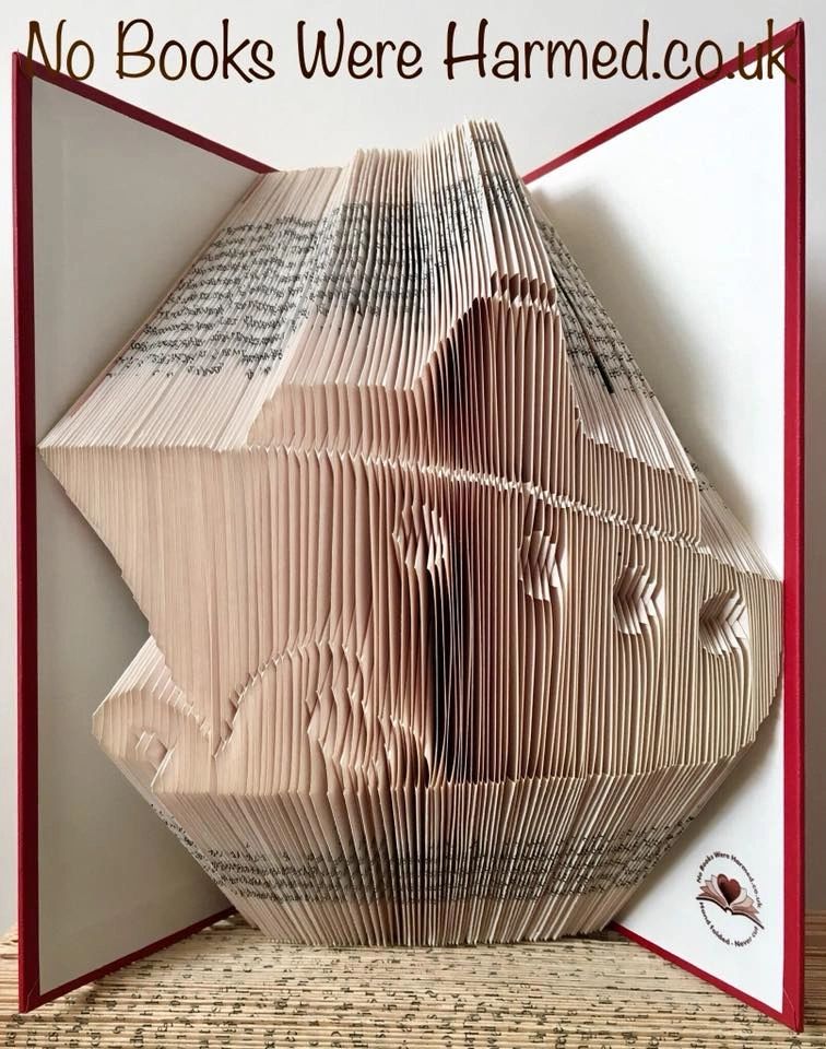 Handcrafted cruise ship art made from vintage books, showcasing intricate folds and unique colors.