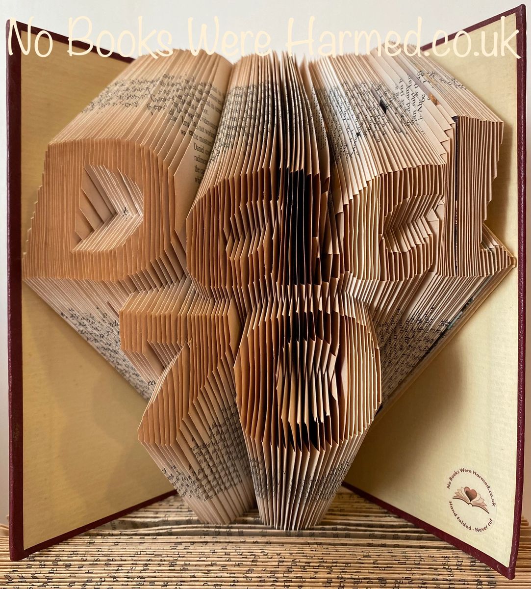 Handcrafted art piece featuring the word 'Dad' over a customizable number, made from vintage book pages, showcasing unique folds and colors.