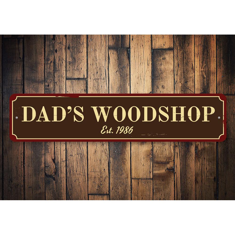 A decorative Dad's Woodshop Sign made of high-quality aluminum, featuring customizable text and pre-drilled holes for easy mounting.