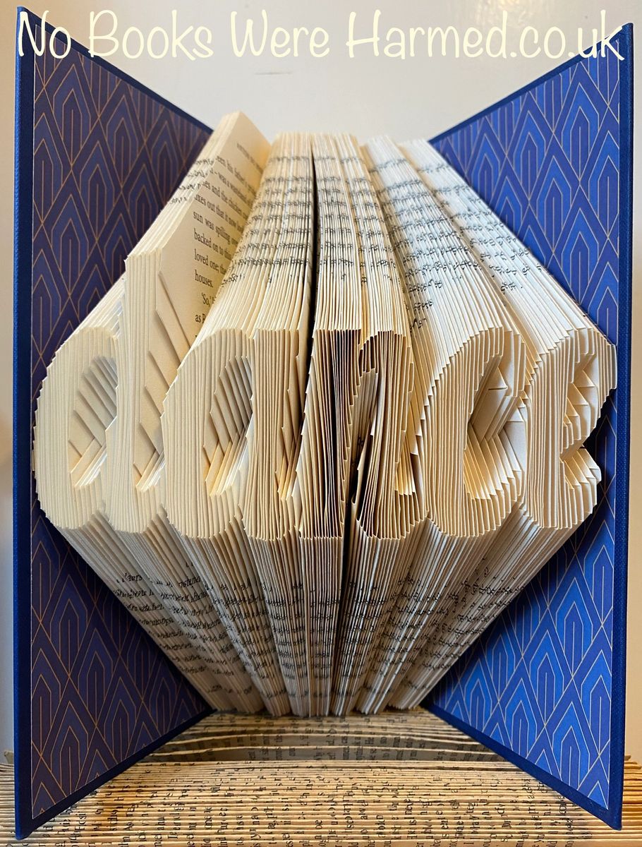 Handcrafted dance-themed book art made from vintage books, showcasing intricate hand-folded pages in various colors.