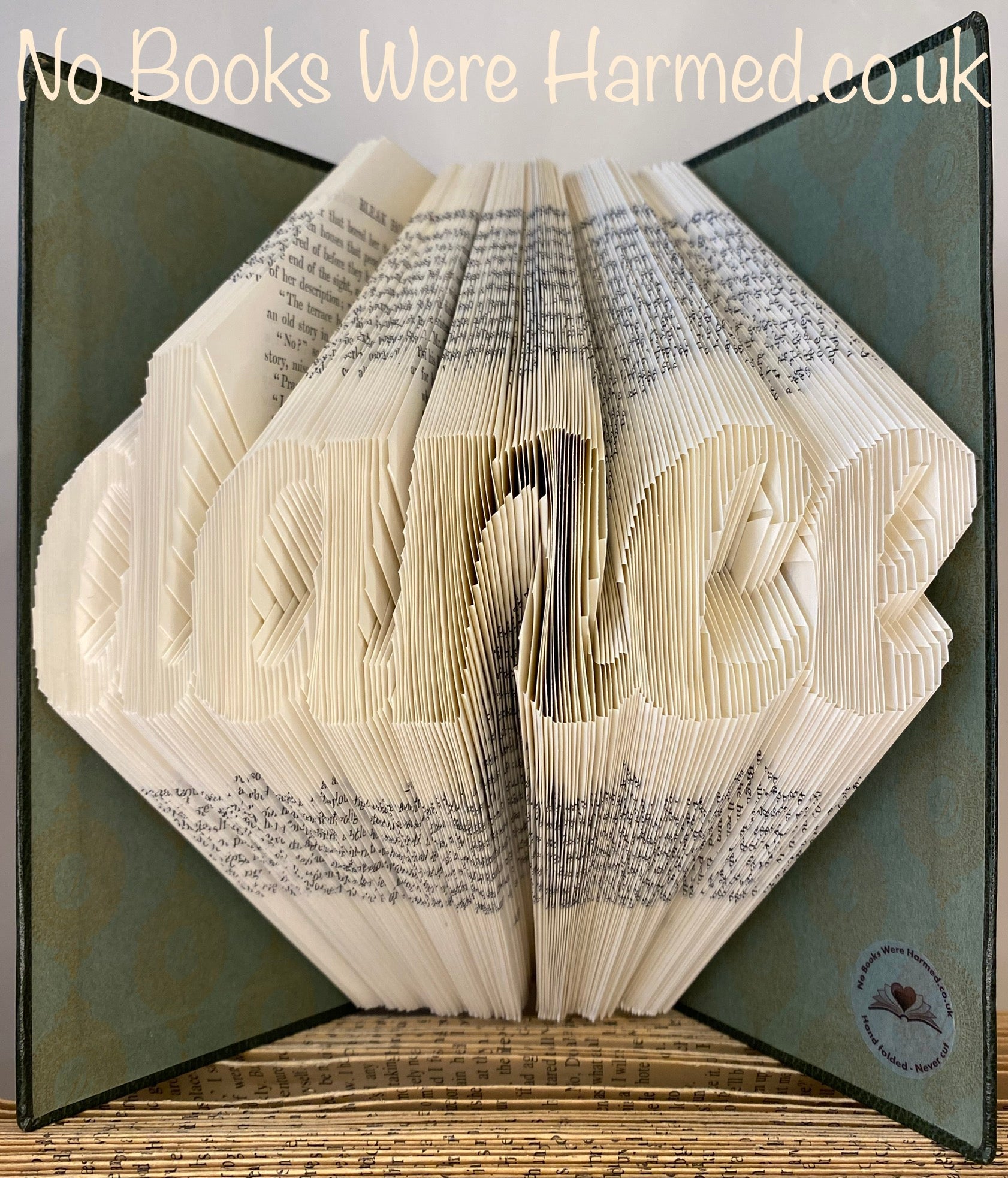 Handcrafted dance-themed book art made from vintage books, showcasing intricate hand-folded pages in various colors.