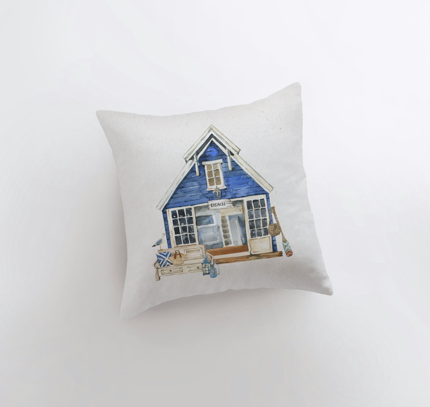 Handmade watercolor throw pillow featuring a beach house design, perfect for coastal home decor.
