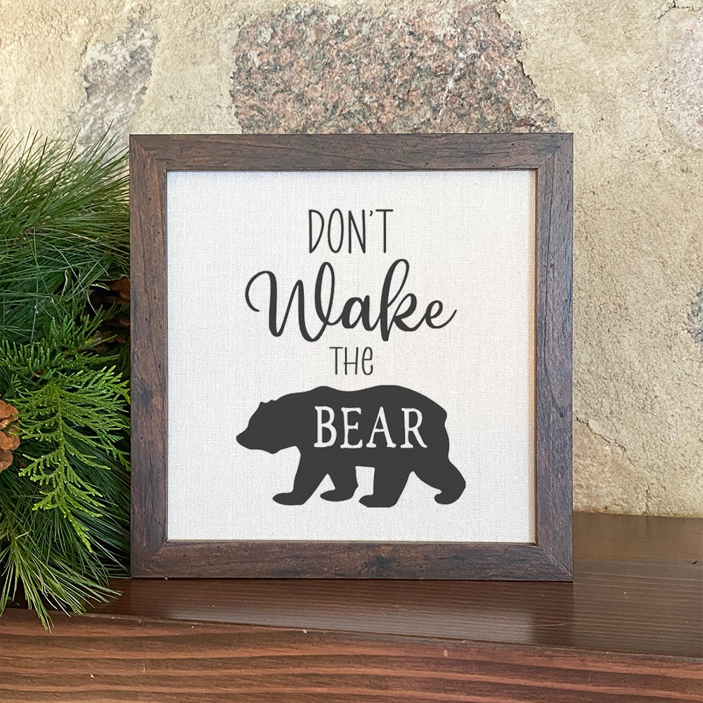 Don't Wake the Bear framed sign with a stylized wood frame, featuring eco-friendly printing on a linen-look background.