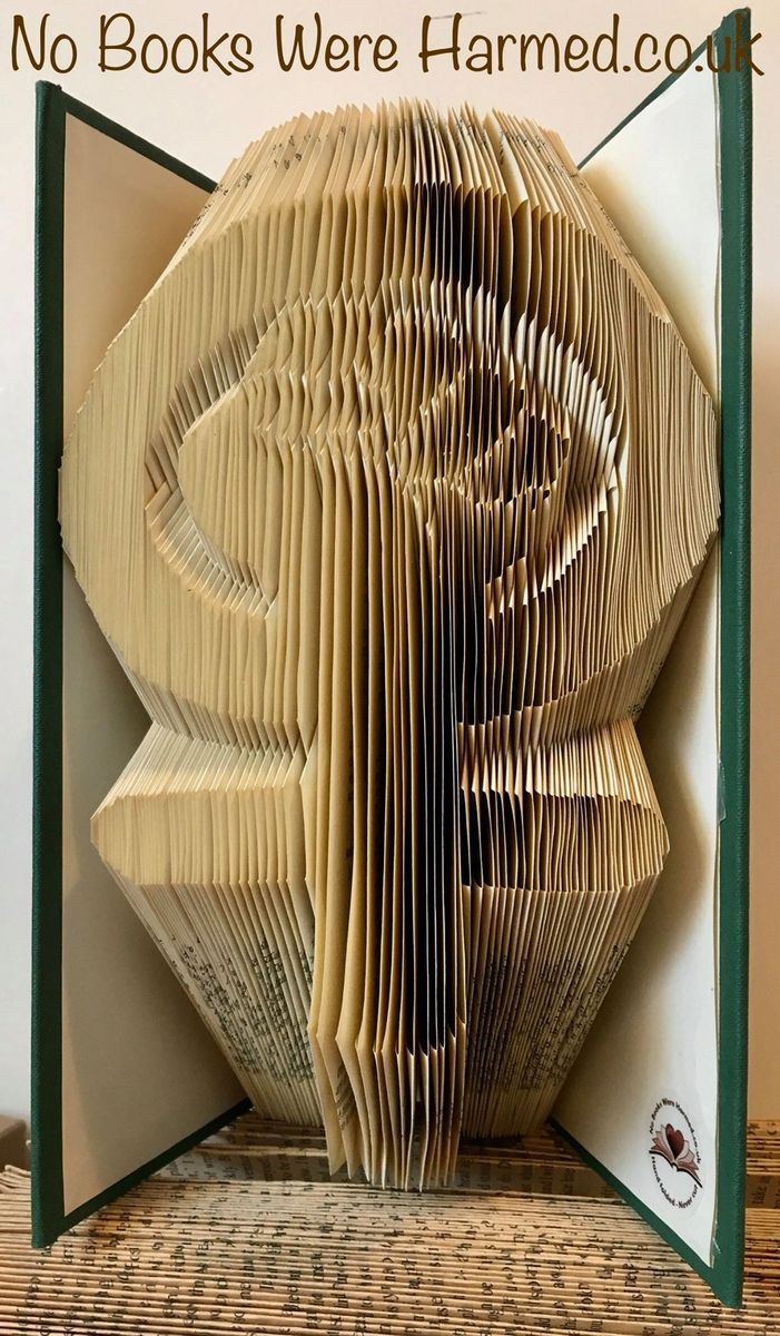 Hand-folded book art piece titled 'Down With The Patriarchy', showcasing intricate designs and vibrant colors from vintage books.