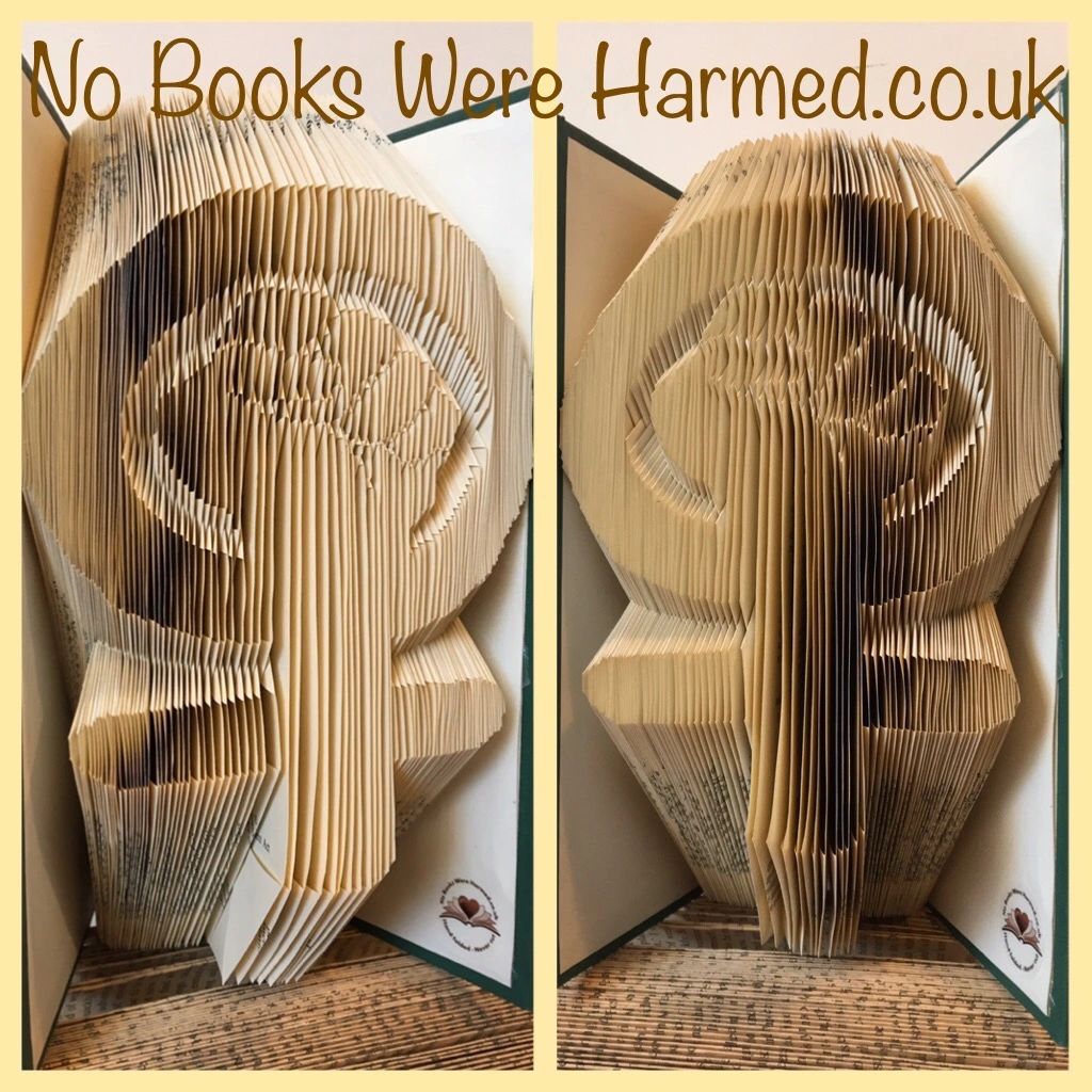 Hand-folded book art piece titled 'Down With The Patriarchy', showcasing intricate designs and vibrant colors from vintage books.