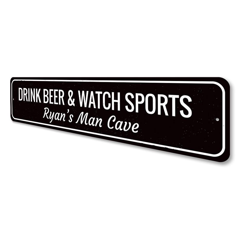 A decorative metal sign that reads 'Drink Beer & Watch Sports', perfect for man caves and game rooms, showcasing quality craftsmanship.