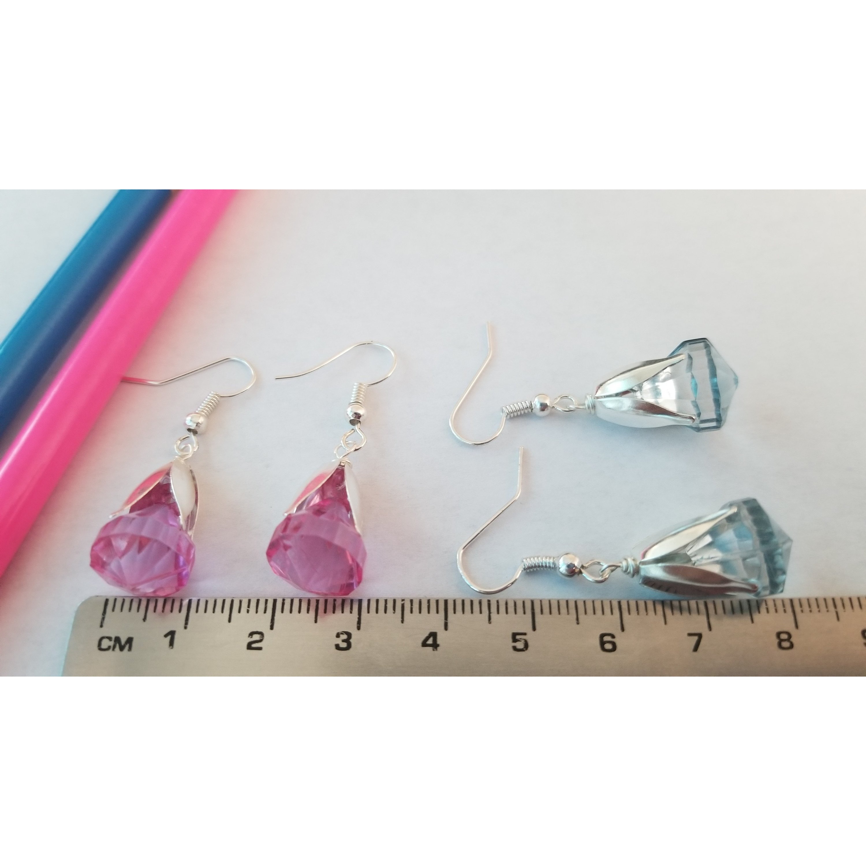 Elegant drop earrings featuring translucent pink and blue beads, showcasing their unique design and colors.