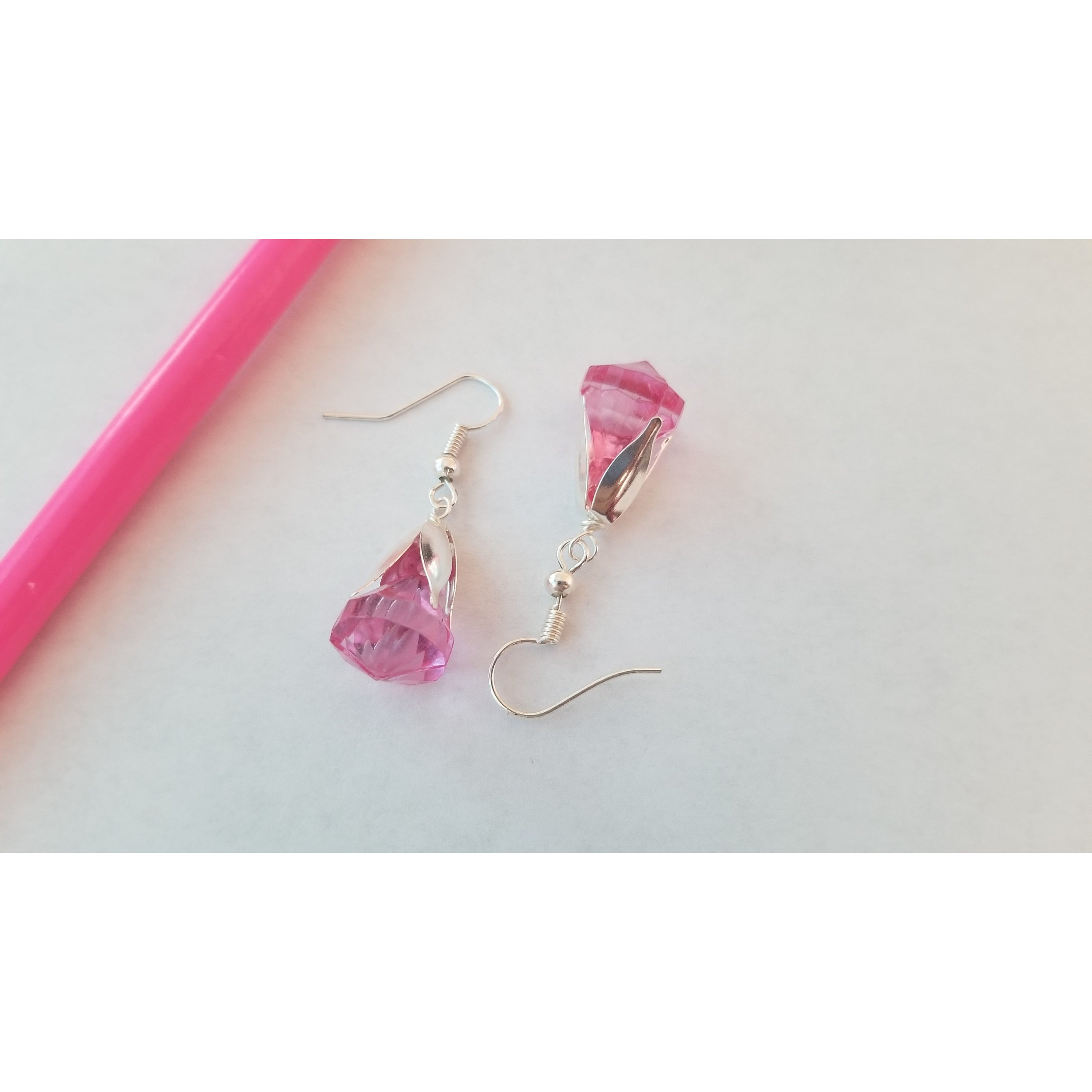 Elegant drop earrings featuring translucent pink and blue beads, showcasing their unique design and colors.