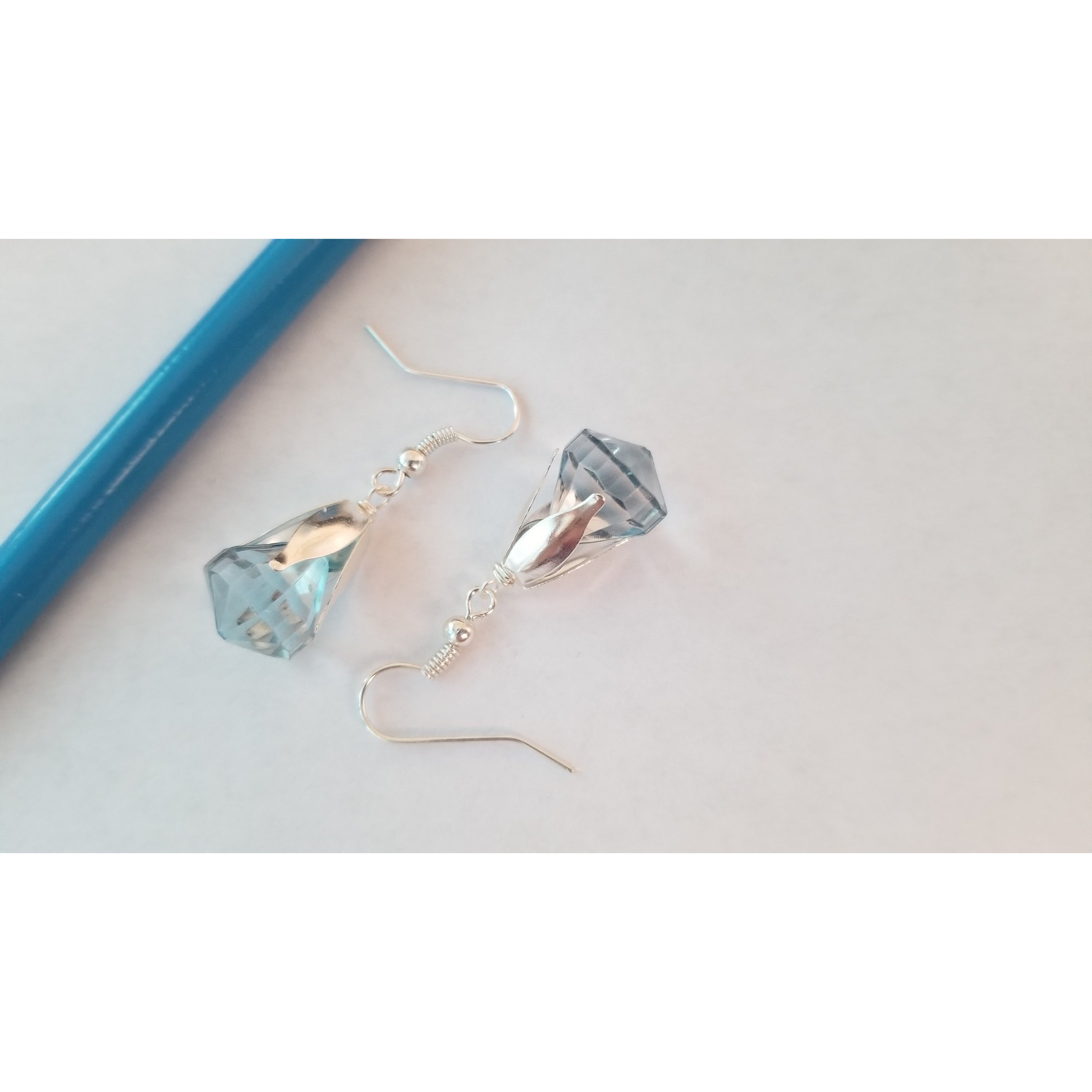 Elegant drop earrings featuring translucent pink and blue beads, showcasing their unique design and colors.