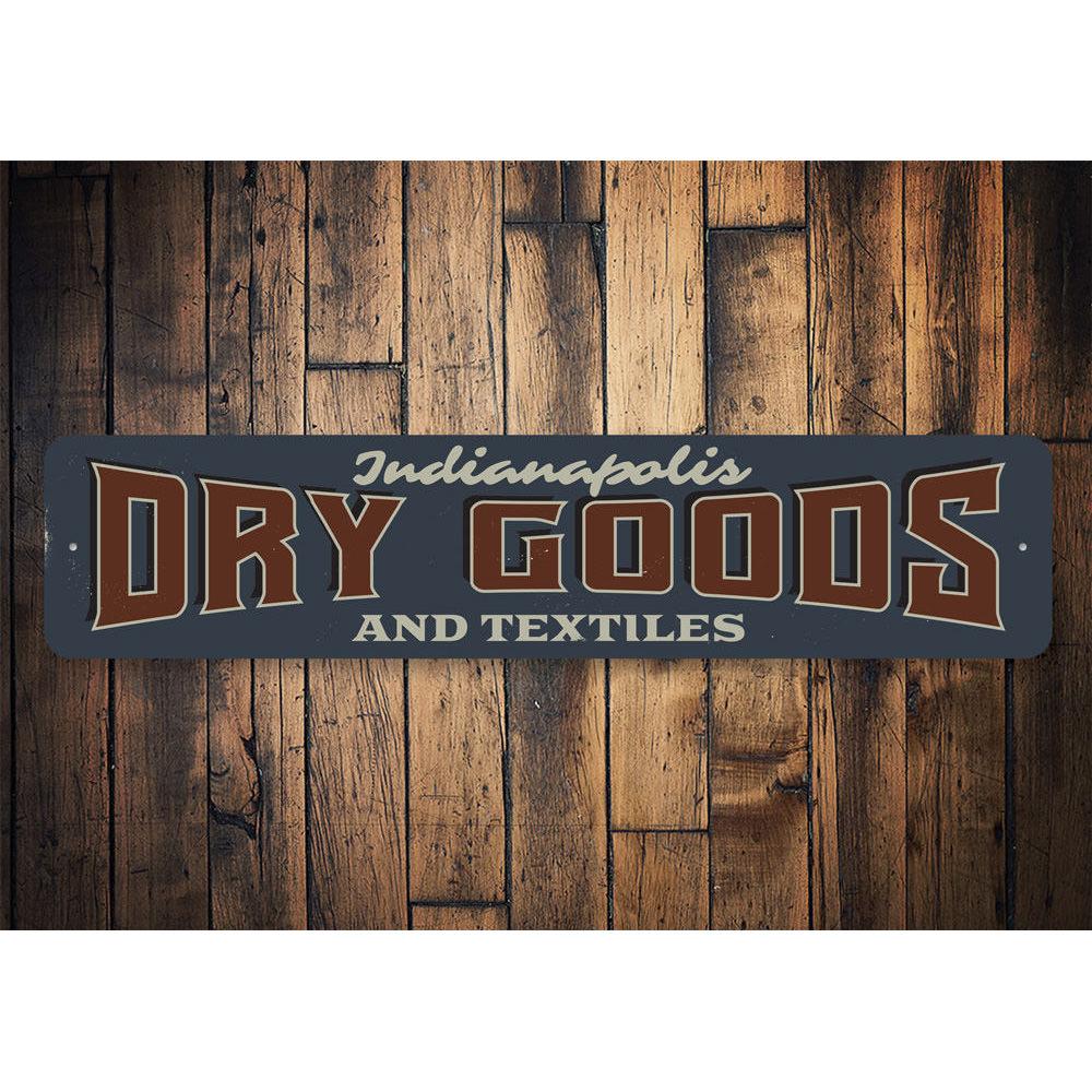 A decorative Dry Goods and Textiles Sign made of high-quality aluminum, featuring customizable text and pre-drilled holes for easy mounting.