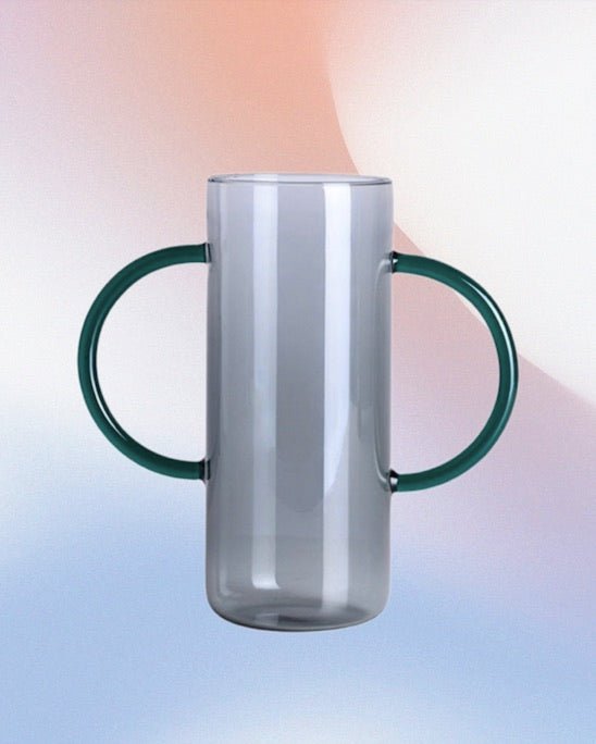 A whimsical dual-handle glass flower vase, handblown with a unique design, perfect for seasonal flowers and elegant table settings.