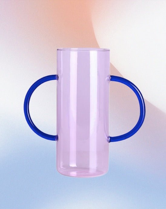 A whimsical dual-handle glass flower vase, handblown with a unique design, perfect for seasonal flowers and elegant table settings.