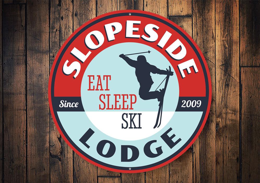 Eat Sleep Ski Circle Sign made of durable aluminum, featuring a circular design with ski-themed graphics, perfect for lodge decor.
