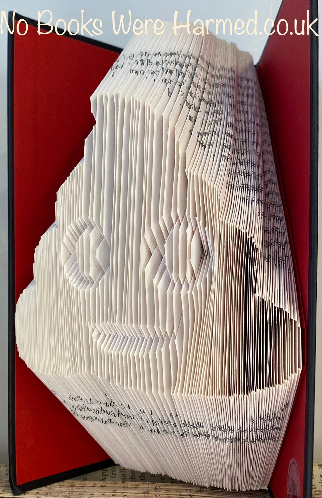 A colorful Emojipoo art piece made from hand-folded pages of vintage books, showcasing intricate designs and unique patterns.