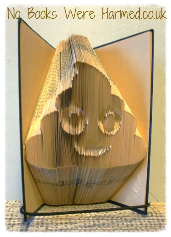 A colorful Emojipoo art piece made from hand-folded pages of vintage books, showcasing intricate designs and unique patterns.