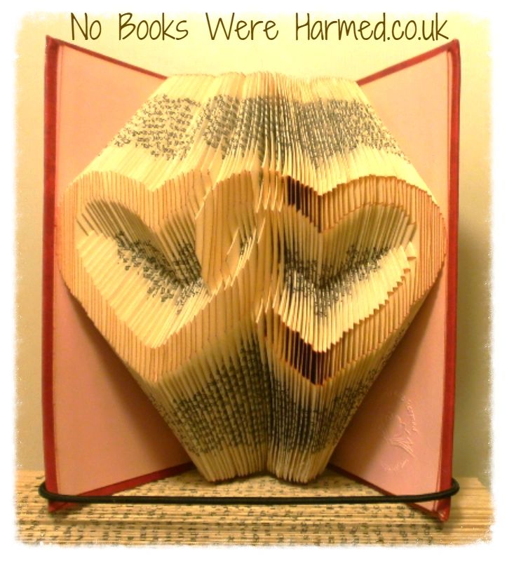 A beautifully crafted entwined love hearts art piece made from vintage book pages, showcasing intricate hand-folded designs.