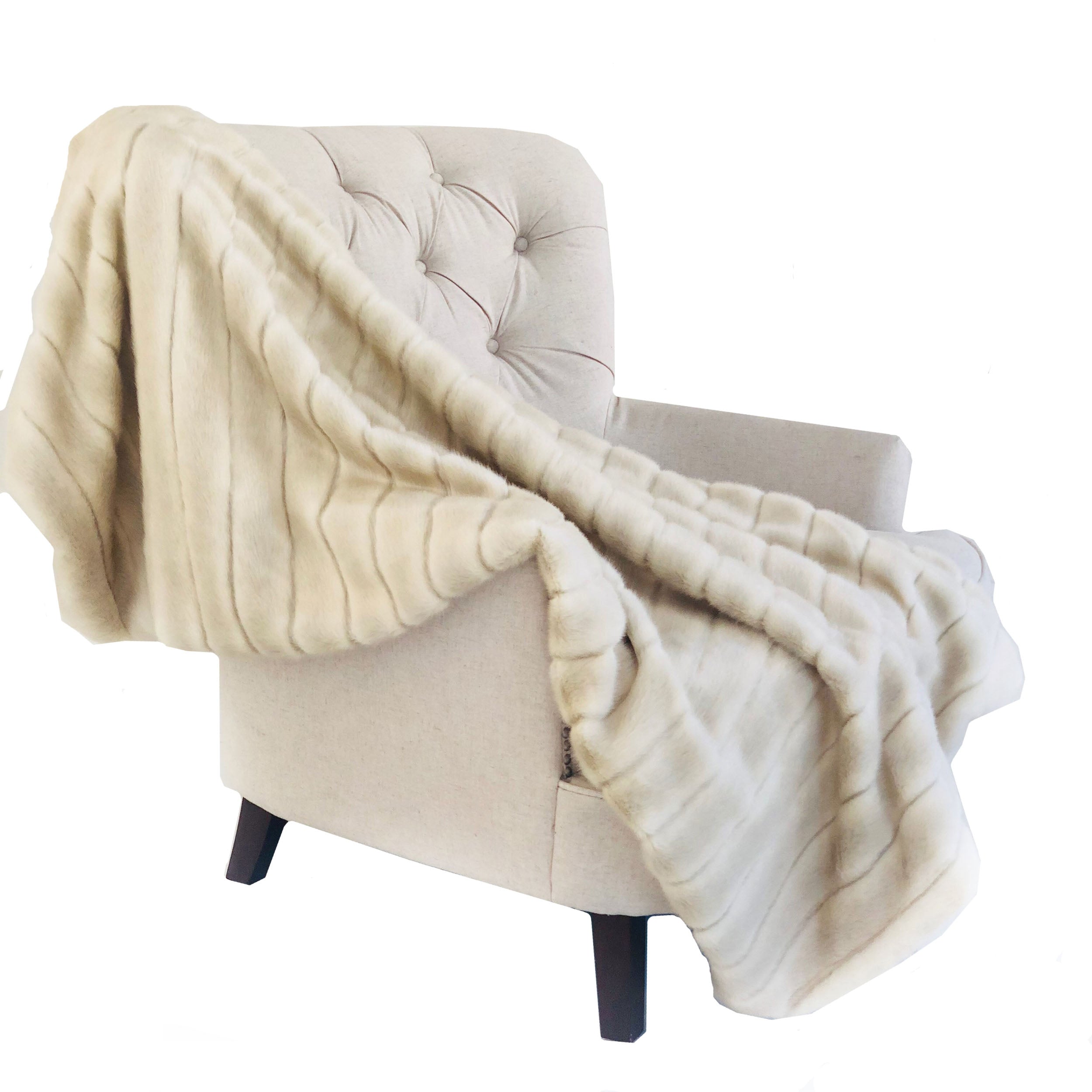 Fancy Mink Faux Fur Ivory Luxury Throw blanket draped elegantly on a couch, showcasing its plush texture and elegant ivory color.