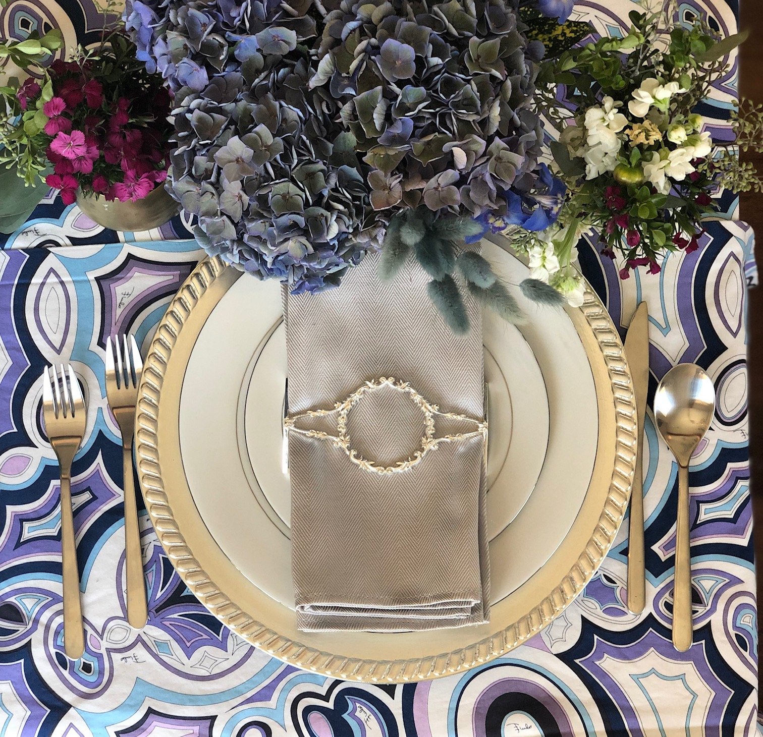 A set of four shiny silver filigree napkin wraps elegantly displayed in a stylish box, showcasing intricate designs.