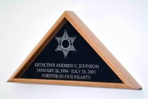 A beautifully crafted flag display case made of solid wood with a glass front, featuring a laser engraved sheriff badge, designed for a burial flag.