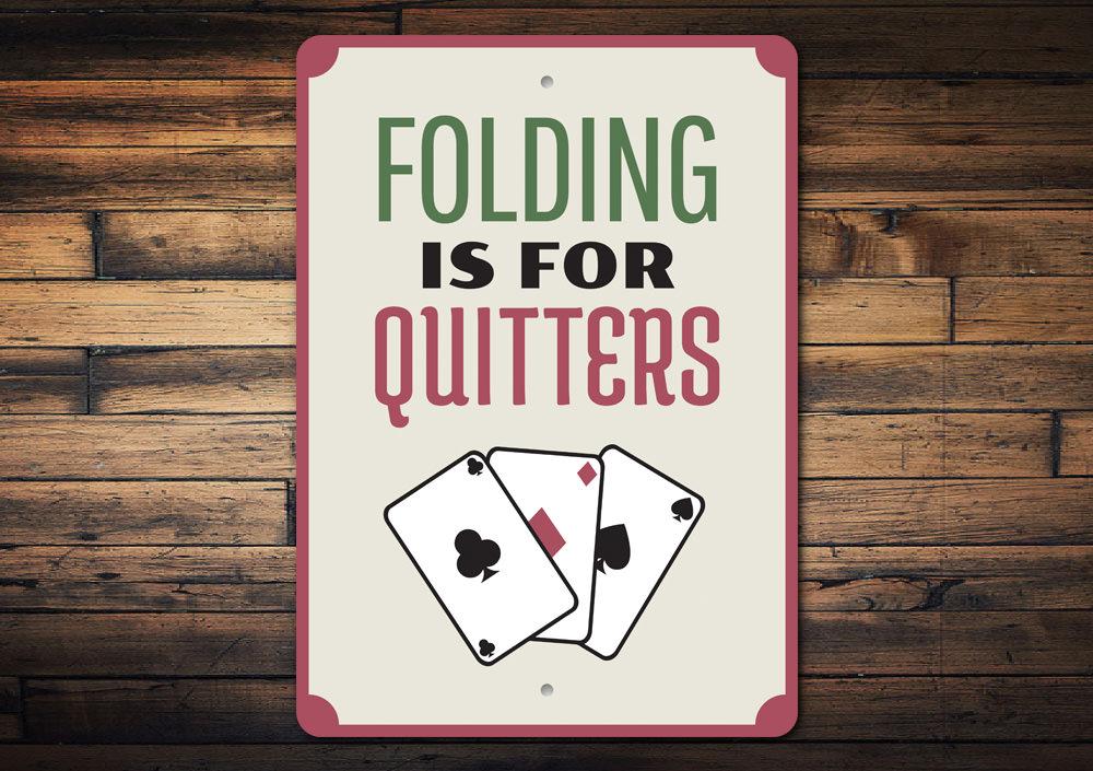 Folding is for Quitters Sign made of aluminum, featuring humorous text, perfect for home decor.