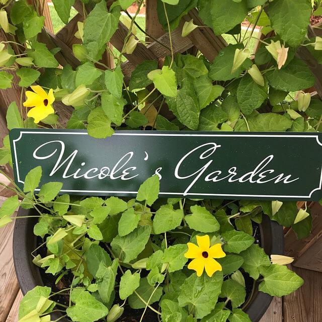 A personalized Garden Name Sign made of durable aluminum, featuring custom text and pre-drilled holes for easy mounting.
