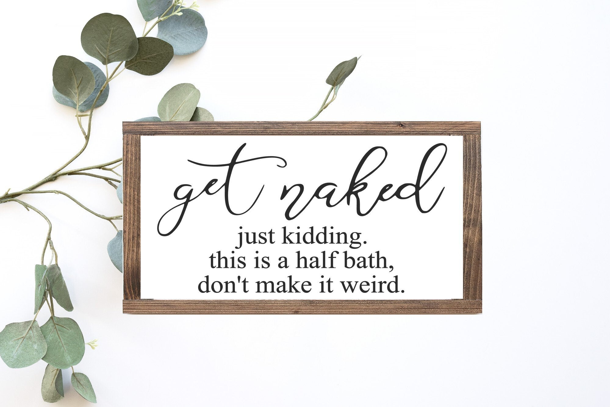 Humorous wooden bathroom sign reading 'Get Naked Just Kidding This Is A Half Bath Don't Make It Weird', showcasing a matte white background and unique wood grain.