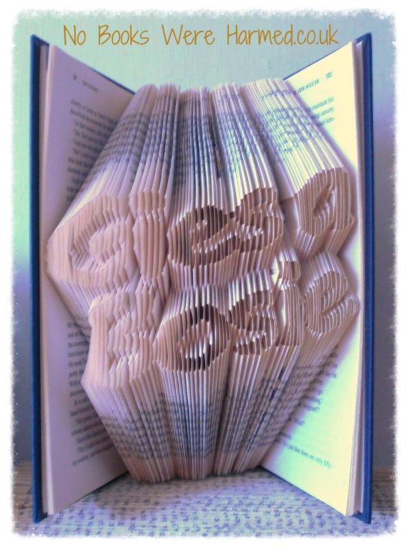 Handcrafted book art piece titled Gies a Bosie, showcasing intricately folded pages from vintage books in unique designs.