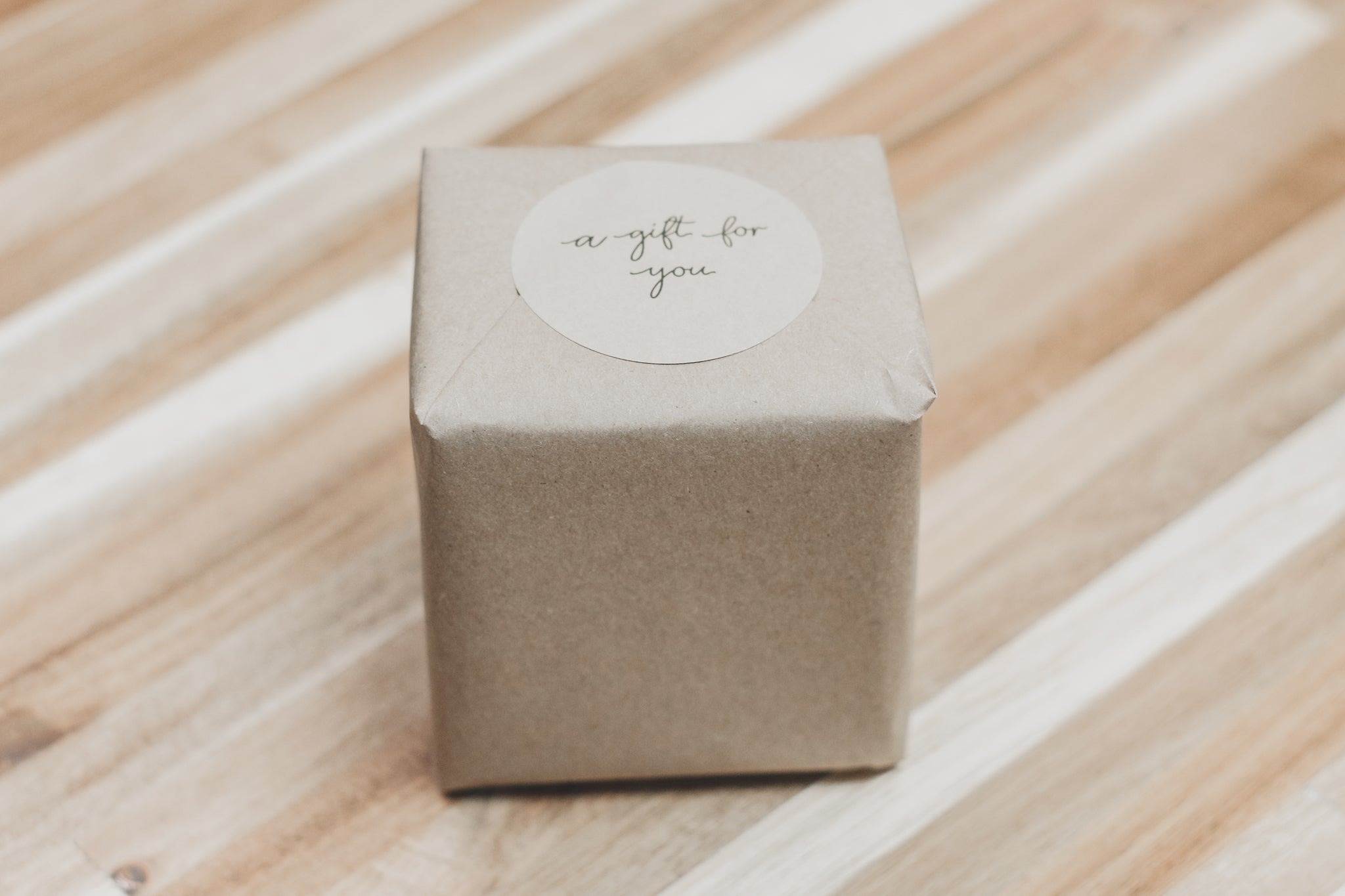 A beautifully wrapped candle in seasonal kraft paper, showcasing elegant designs.