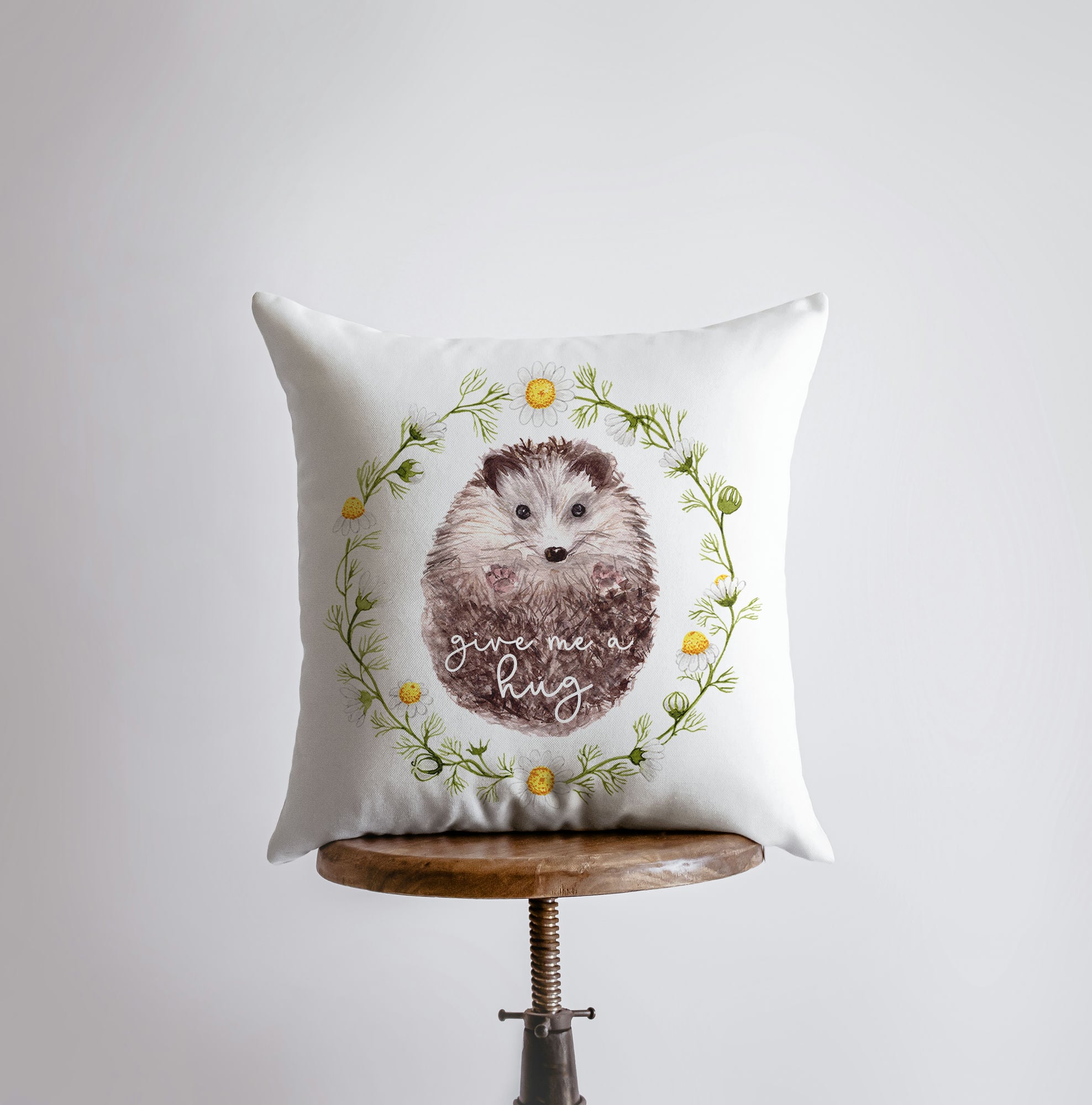 A cozy hedgehog-themed pillow cover with the text 'Give Me a Hug' on a white background, showcasing its cute design and concealed zipper.
