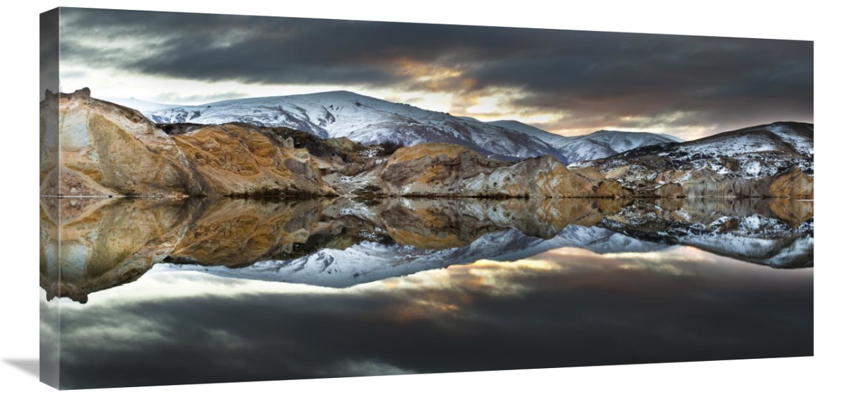 Snowy mountains reflected in water.