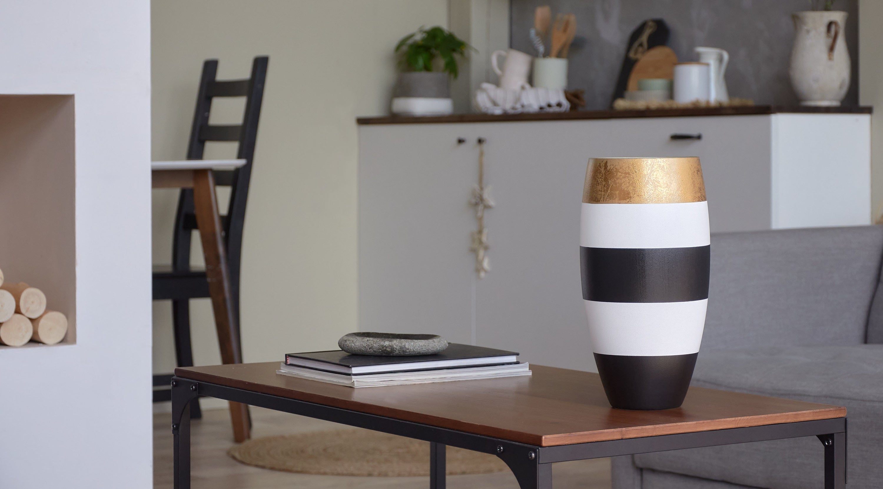 A beautifully hand-painted glass vase in gold, black, and white, showcasing intricate designs perfect for floral arrangements.