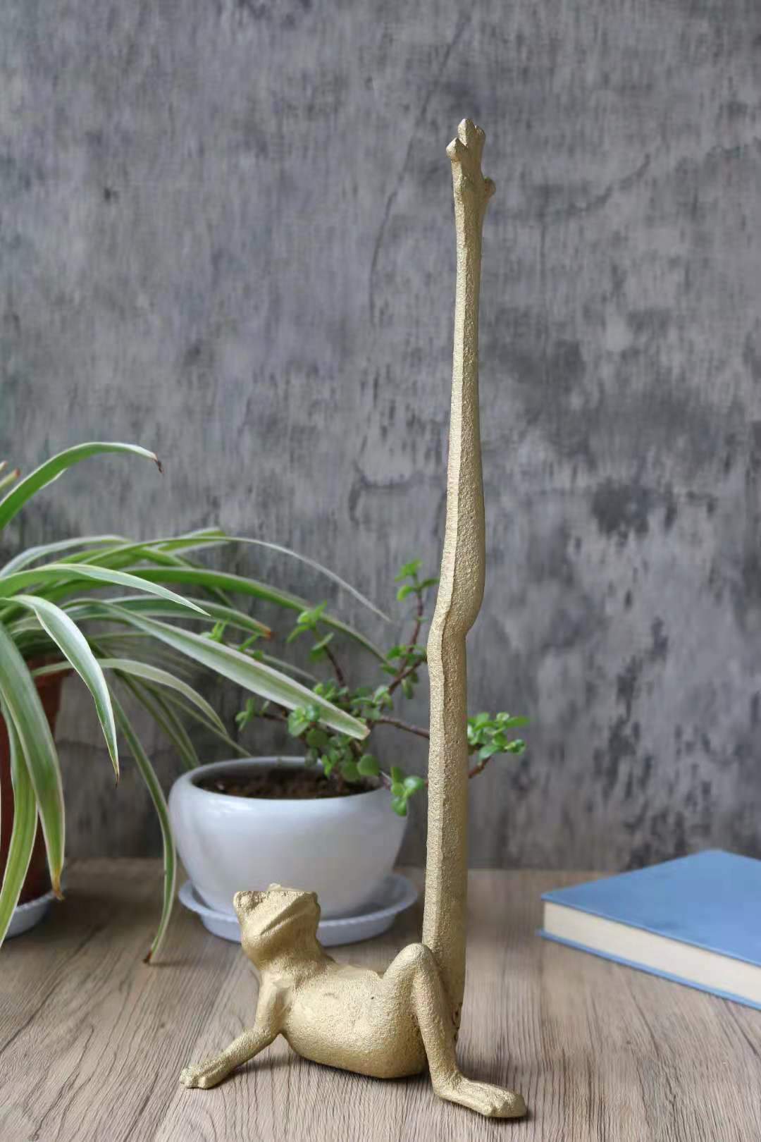 Gold Frog Paper Towel Holder made of cast iron, featuring a whimsical frog design with a hand brushed gold finish.