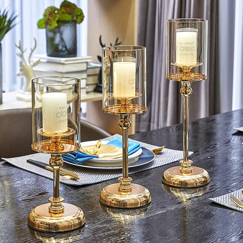 Elegant golden glass candle holders designed for pillar candles, showcasing a luxurious finish and reflective surface.