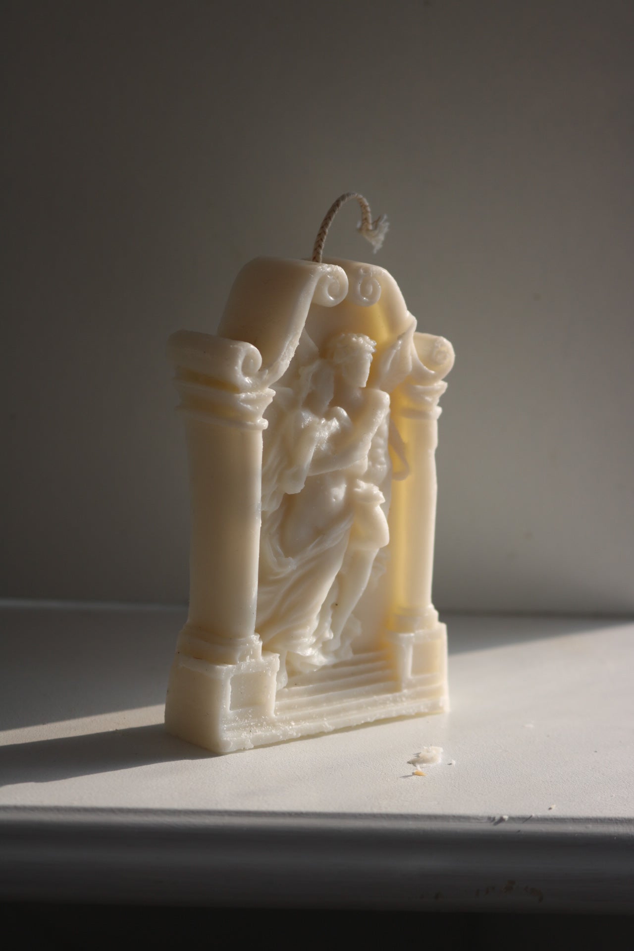 A beautifully crafted Greek statue candle made from soy wax blend, showcasing intricate details and an elegant design.