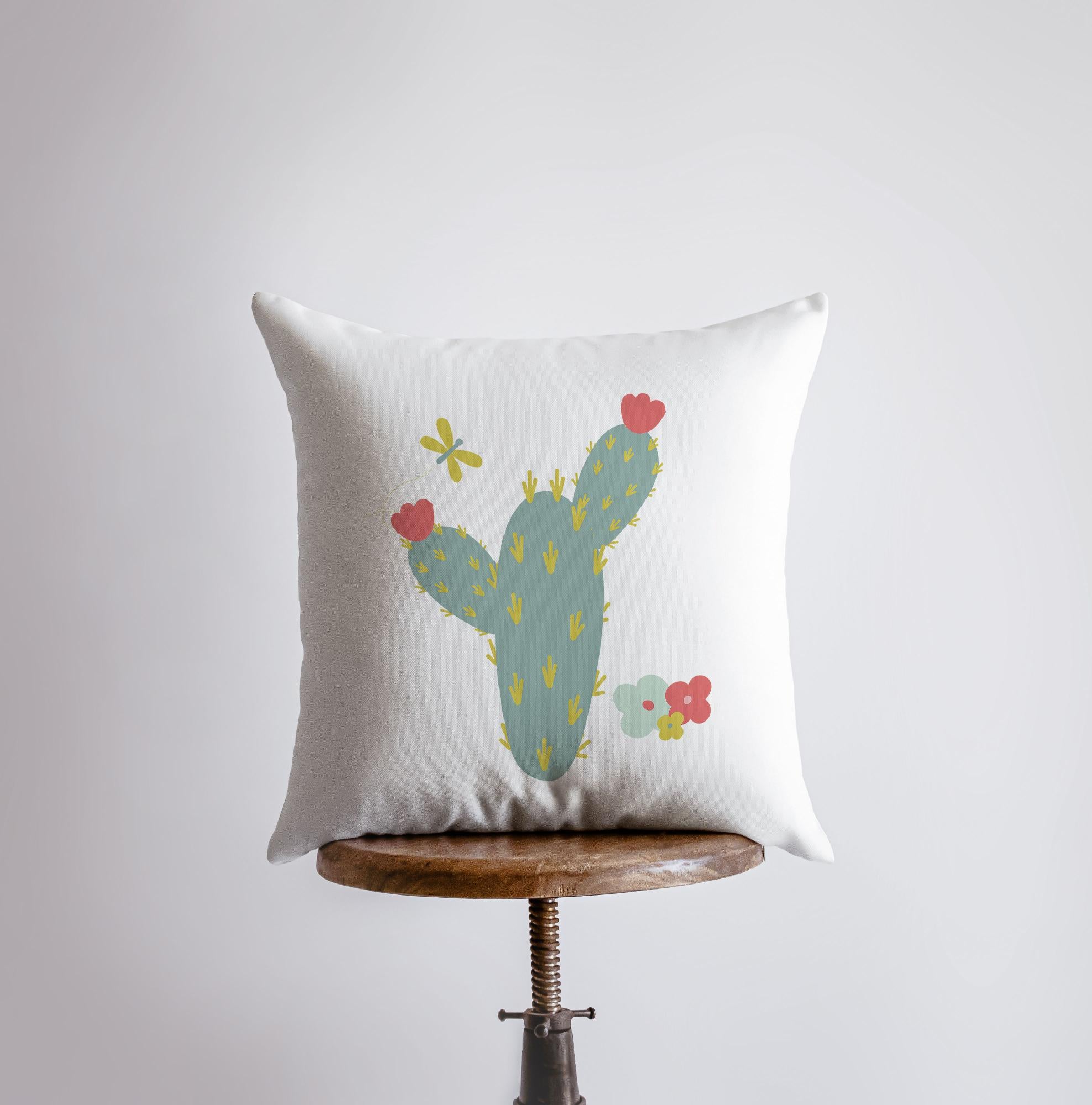 A vibrant green cactus pillow cover featuring a colorful cactus design on the front and a white back, showcasing its handcrafted quality.