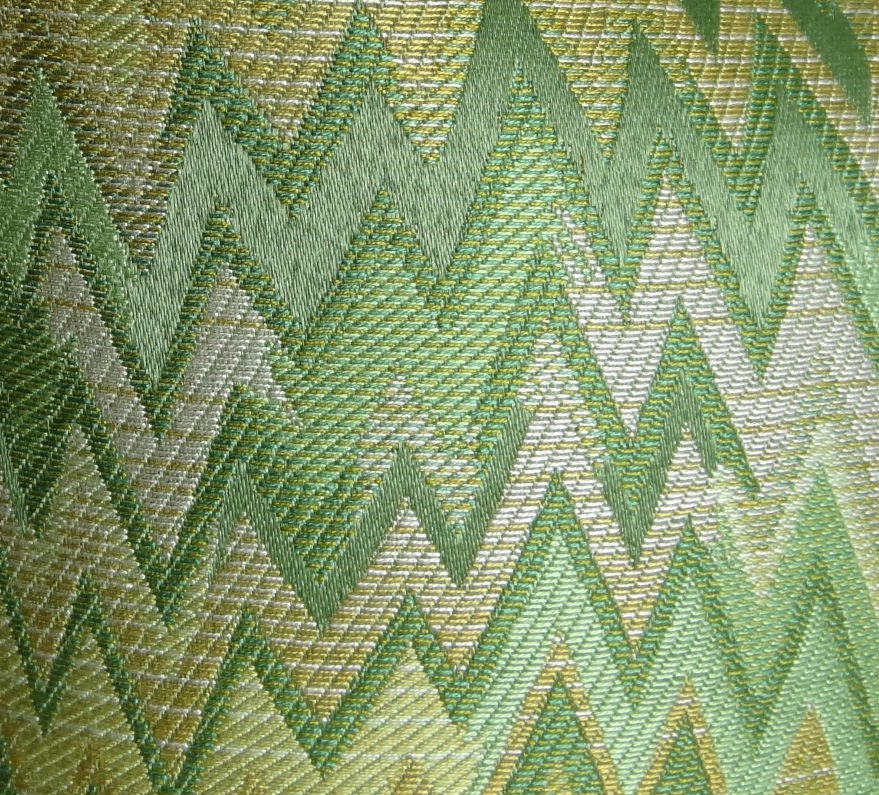 A luxurious handmade pillow featuring a green citrine and taupe chevron pattern, showcasing an invisible zipper and double-sided design.