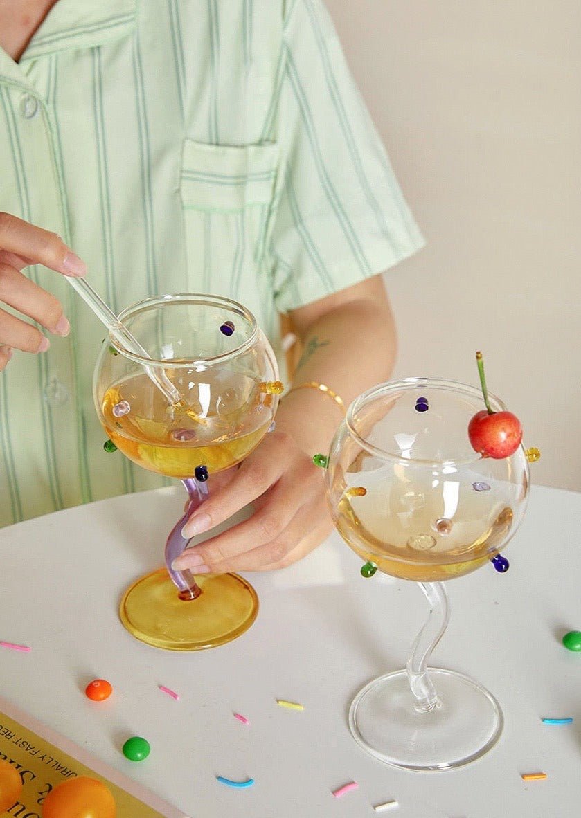 Colorful hand blown wine glasses with wavy stems, inspired by rainbow sprinkles, showcasing artisan craftsmanship.