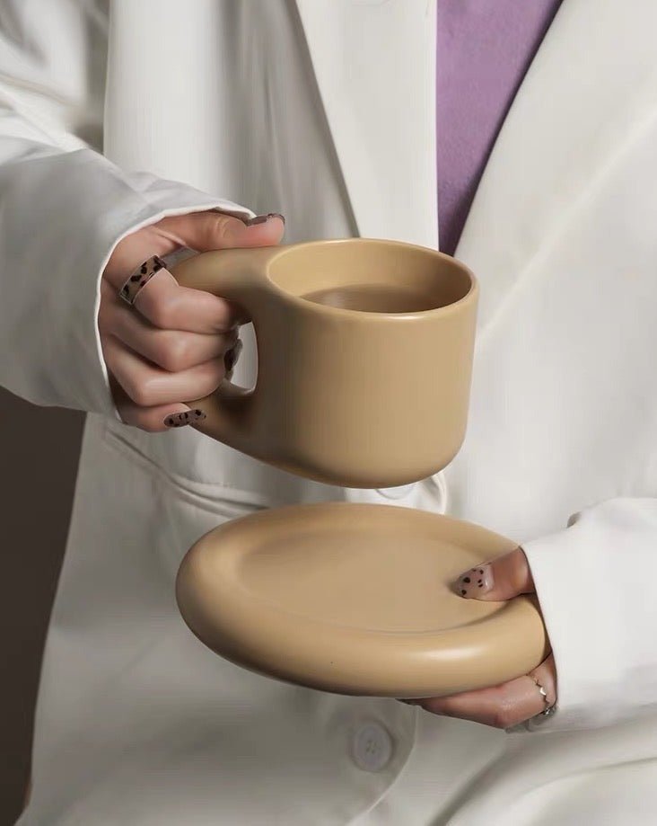 A set of handcrafted Bauhaus ceramic chubby mugs with smooth glaze and gentle curves, showcasing their unique design and craftsmanship.