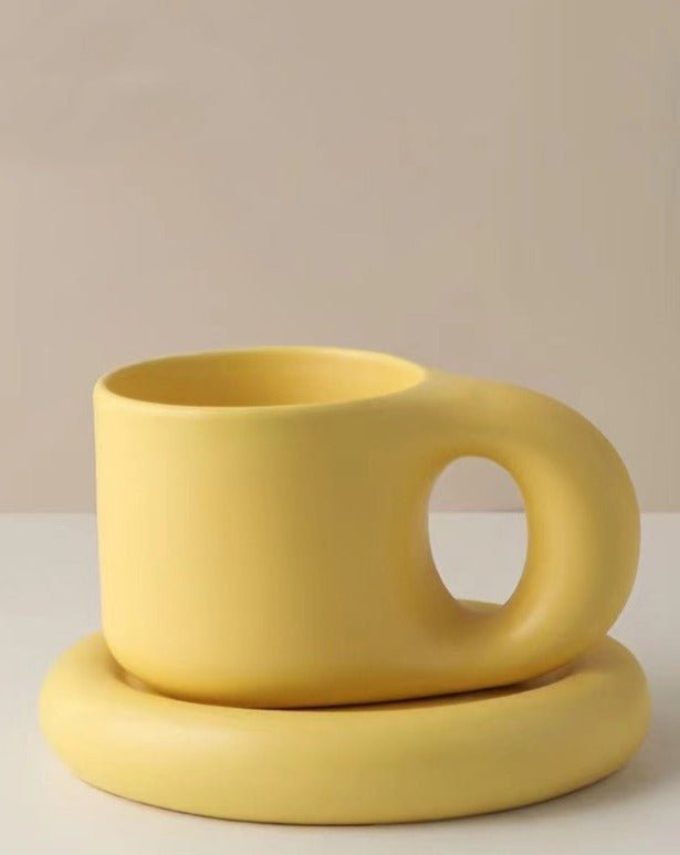 A set of handcrafted Bauhaus ceramic chubby mugs with smooth glaze and gentle curves, showcasing their unique design and craftsmanship.