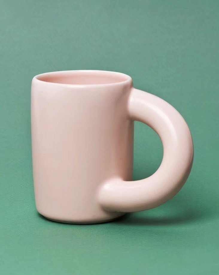 A set of handcrafted ceramic chubby mugs featuring a big twisted handle, available in silver, mango, and peach colors, perfect for coffee or tea.