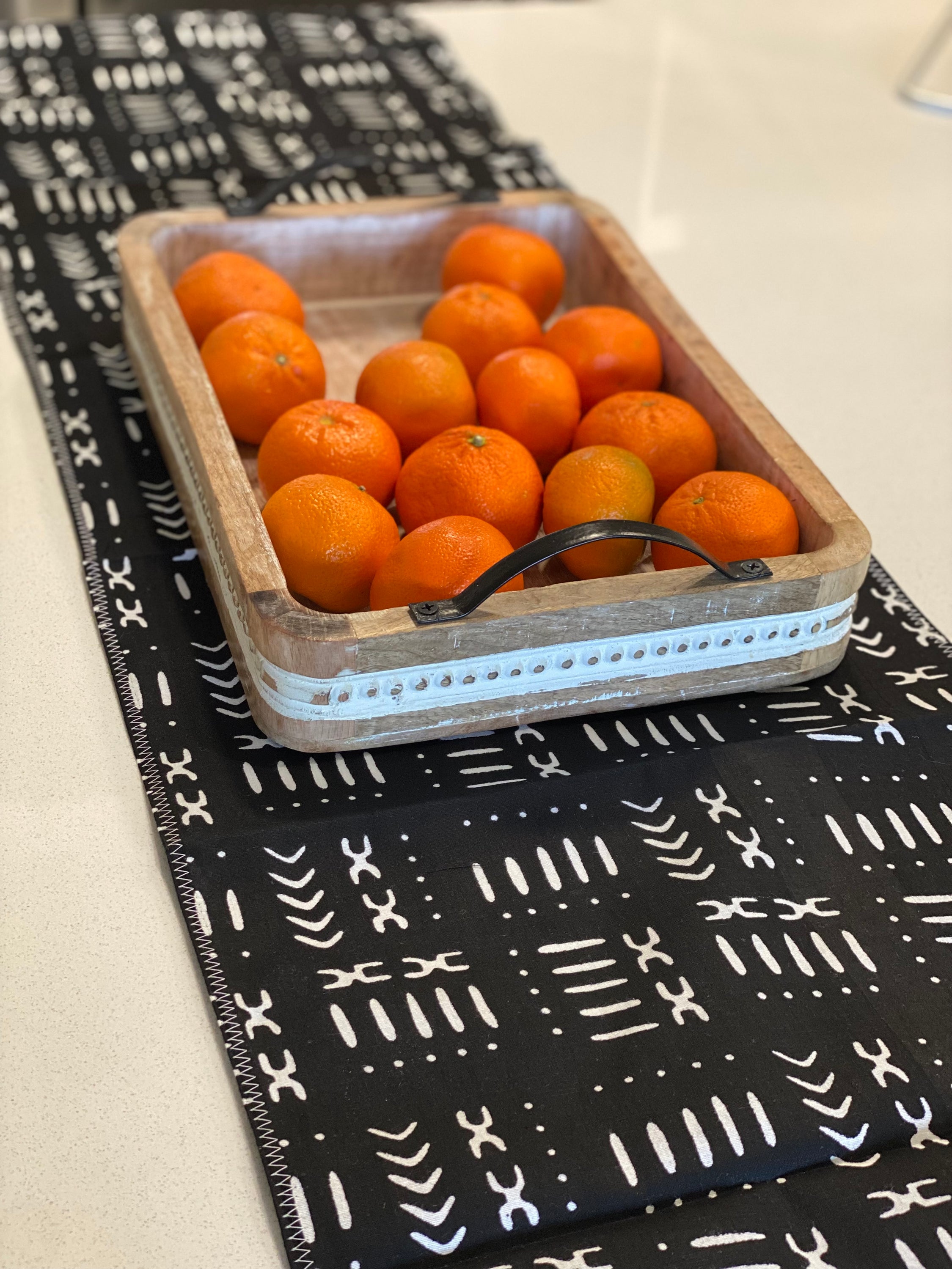Handmade coffee table runner in black mudcloth featuring authentic wax print, showcasing intricate patterns and textures.
