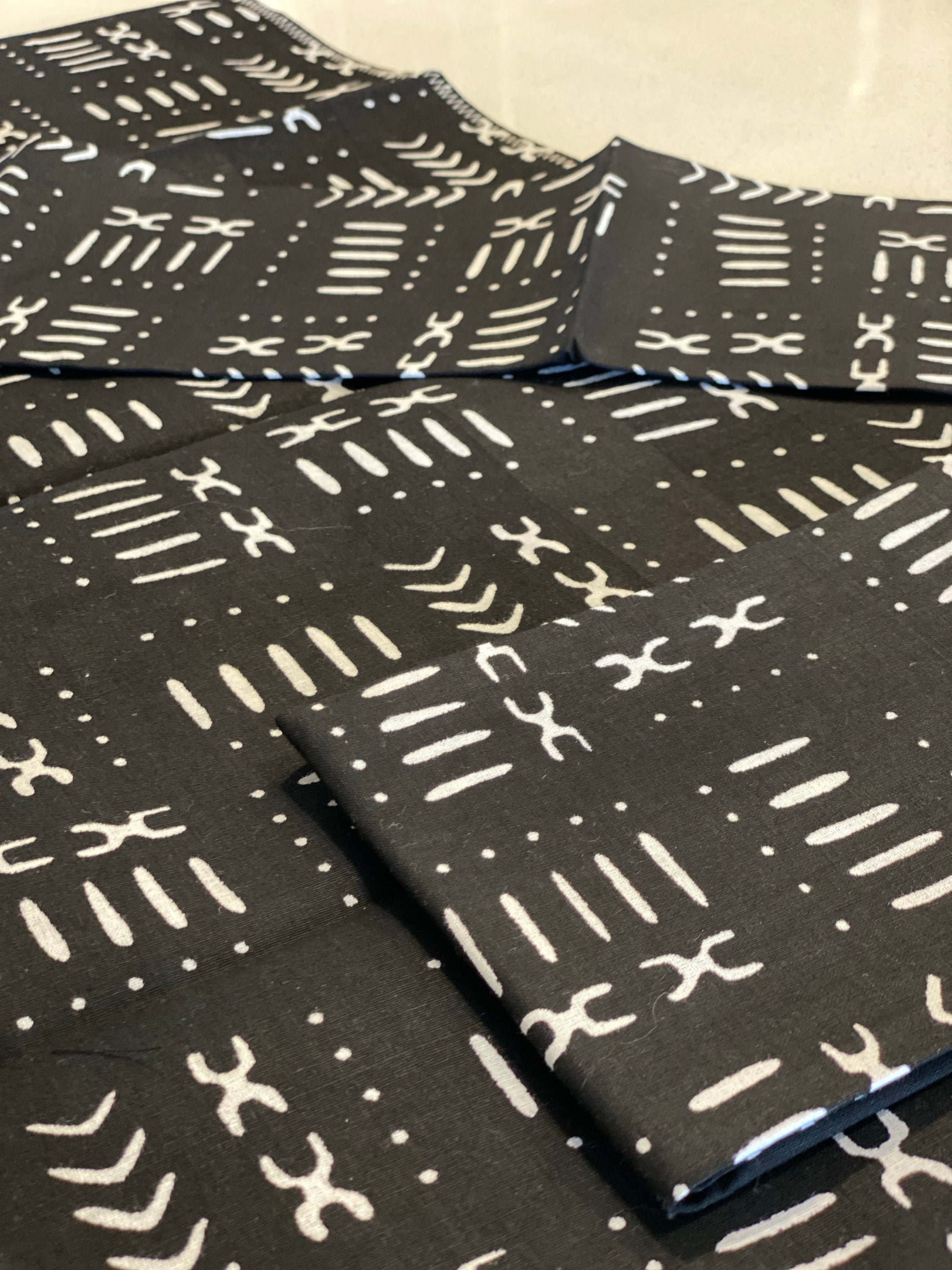 Handmade coffee table runner in black mudcloth featuring authentic wax print, showcasing intricate patterns and textures.