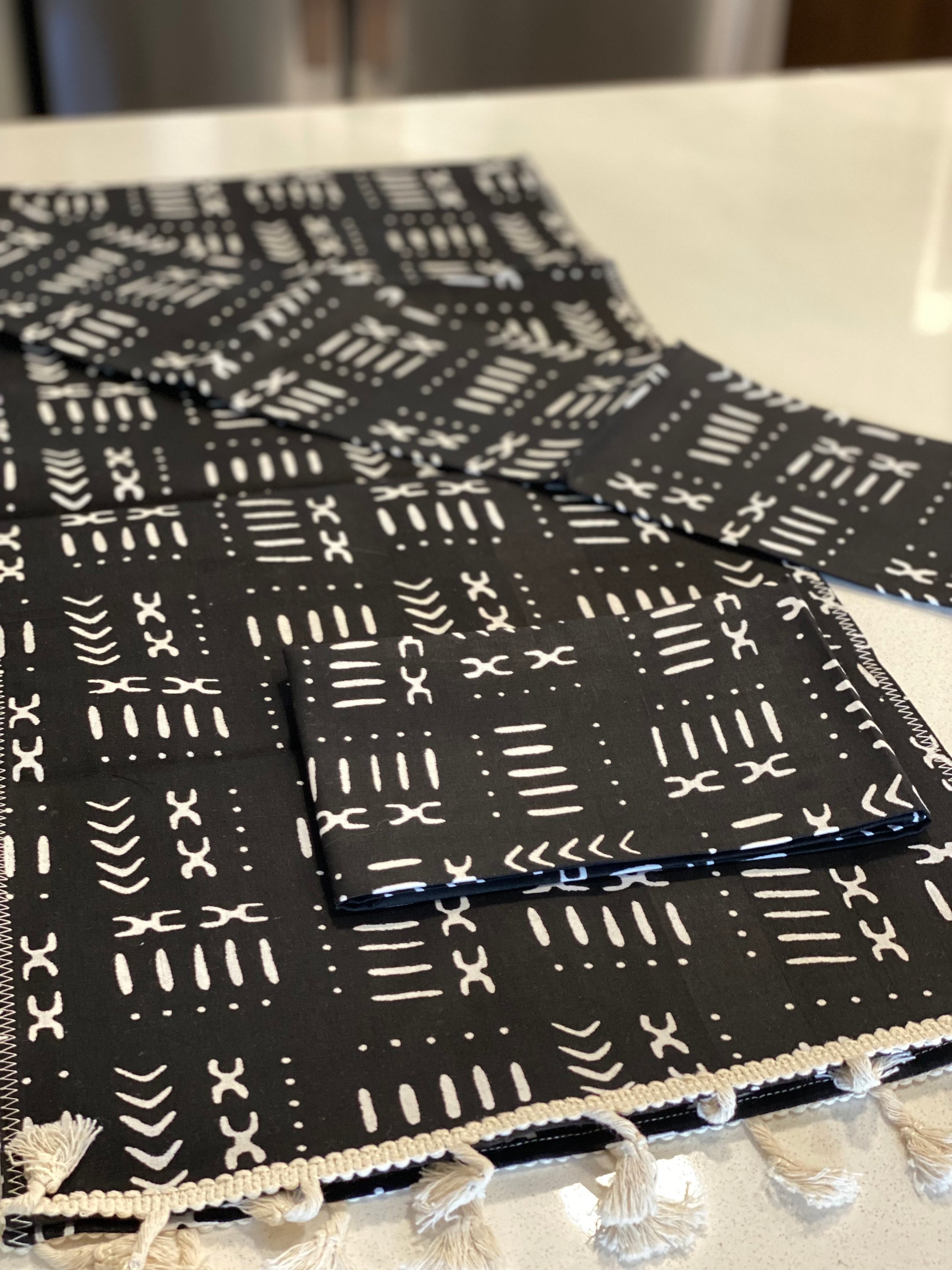 Handmade coffee table runner in black mudcloth featuring authentic wax print, showcasing intricate patterns and textures.