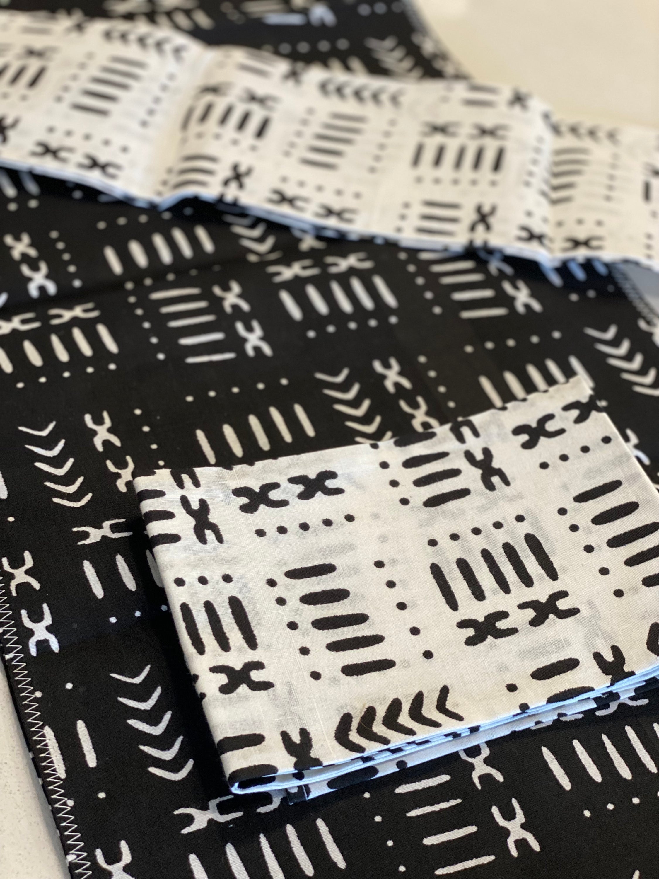 Handmade coffee table runner in black mudcloth featuring authentic wax print, showcasing intricate patterns and textures.