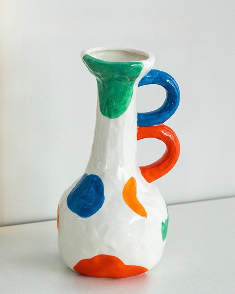 A colorful handpainted contemporary abstract ceramic vase featuring whimsical designs and vibrant colors, perfect for home decor.