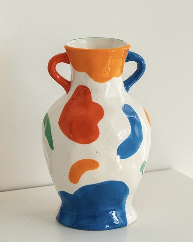 A colorful handpainted contemporary abstract ceramic vase featuring whimsical designs and vibrant colors, perfect for home decor.