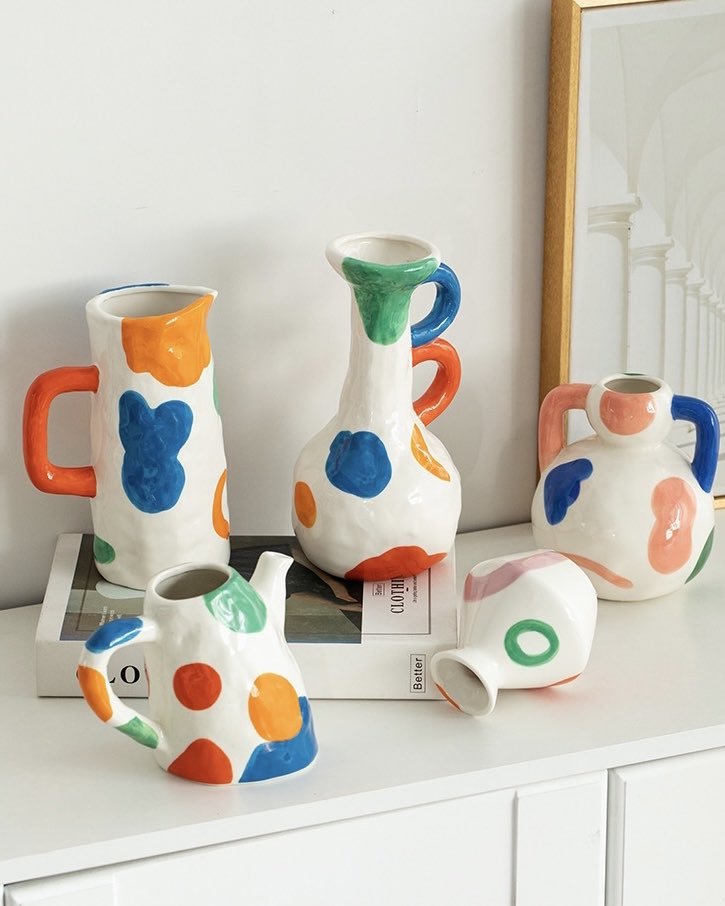 A colorful handpainted contemporary abstract ceramic vase featuring whimsical designs and vibrant colors, perfect for home decor.