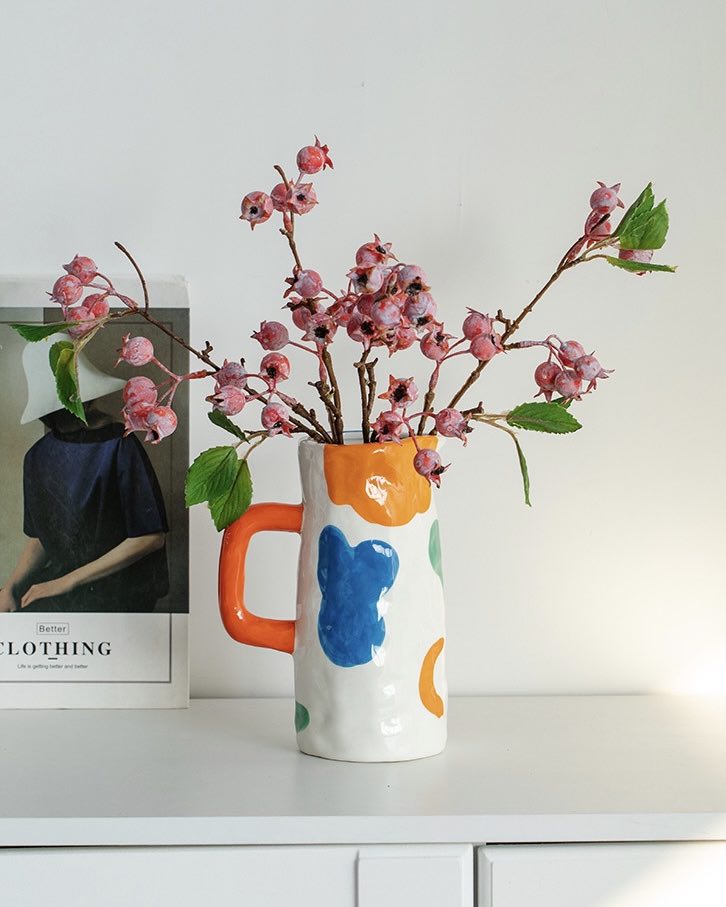 A colorful handpainted contemporary abstract ceramic vase featuring whimsical designs and vibrant colors, perfect for home decor.