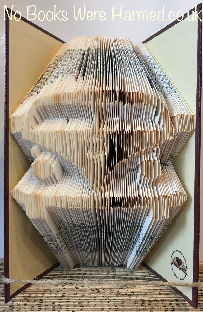 Handcrafted camper van art made from vintage book pages, showcasing intricate folds and unique colors.